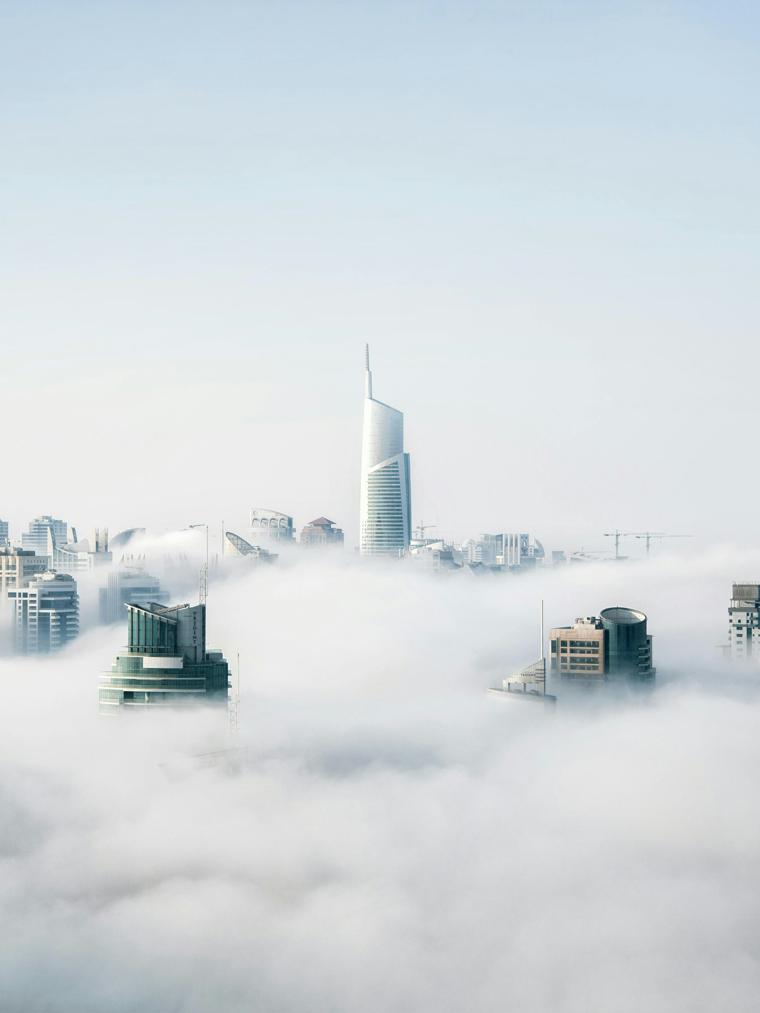 City skyline emerging above the clouds